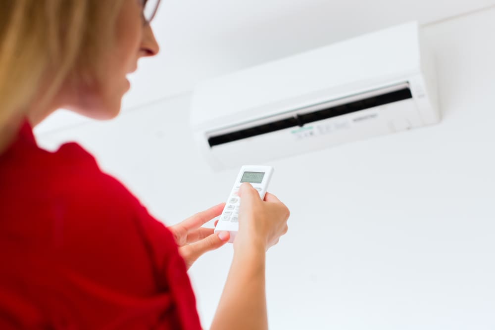 Person adjusting air conditioner remote