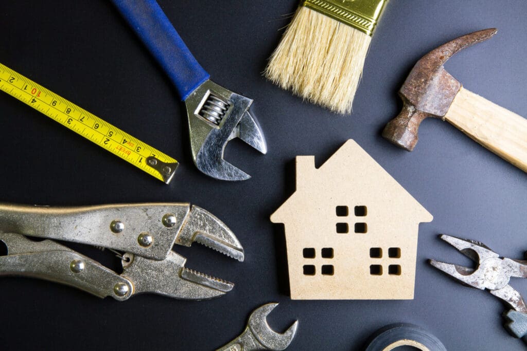 Tools arranged around a house silhouette.