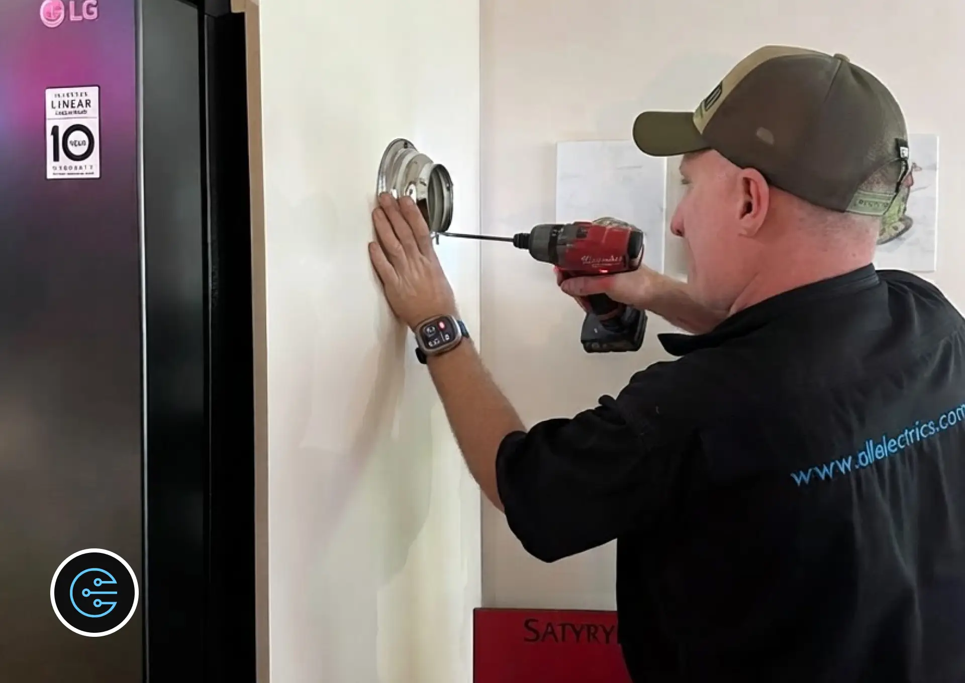 Leonard at All Electrics drilling a chrome mounting base for an antique exit light into the wall.