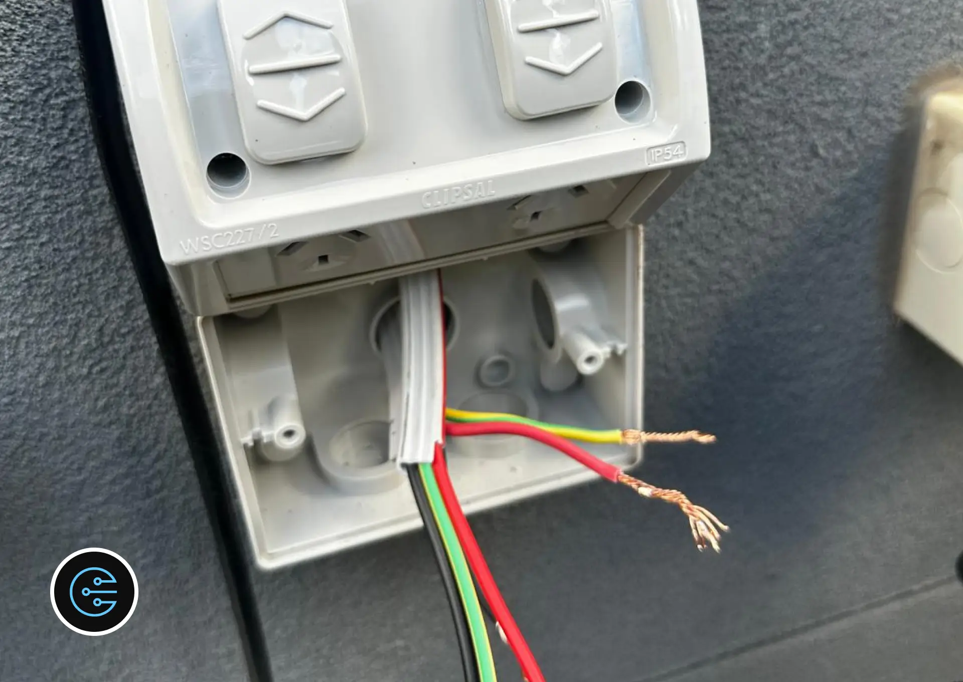 New Clipsal IP54 double outdoor power point open on a wall with the cable and stripped wires ready to connect.