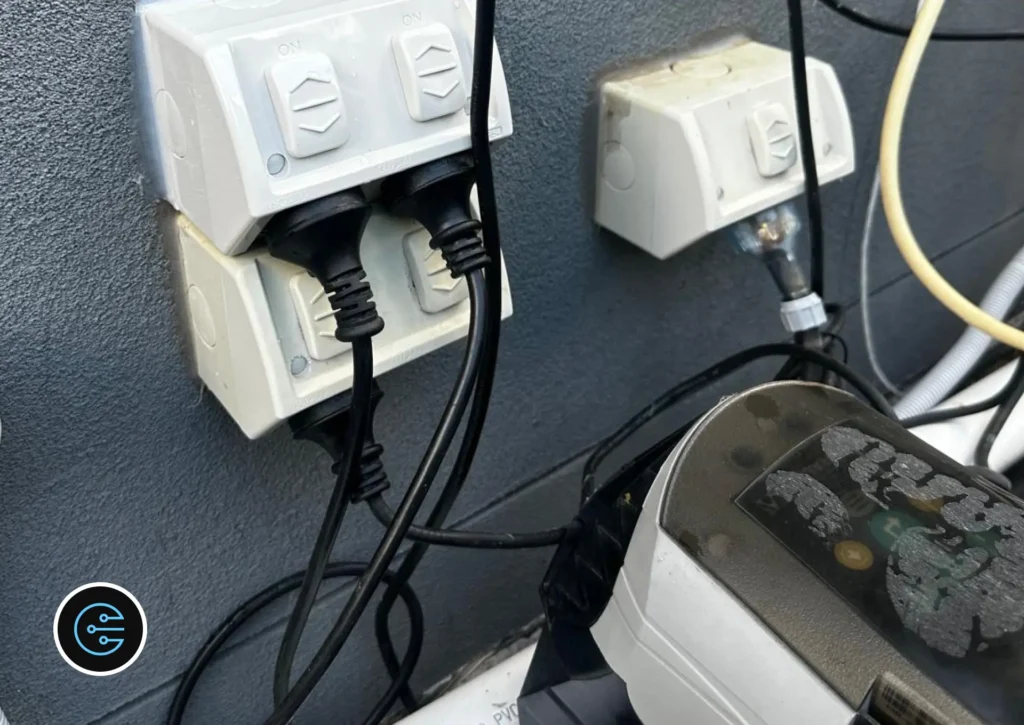 New double outdoor power point installed above the original one, with two pool equipment plugs connected.